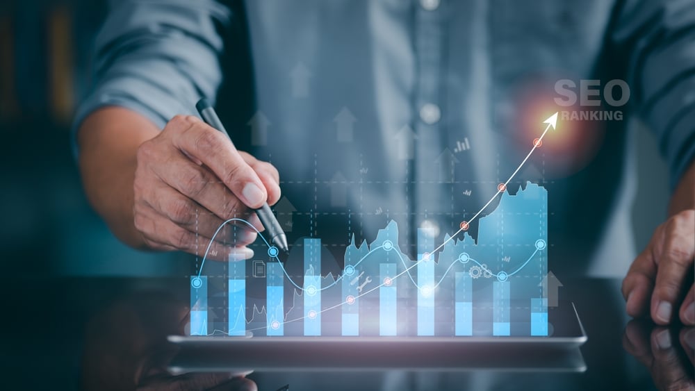 A,Marketer,Holds,A,Pen,Pointing,To,A,Graph,And