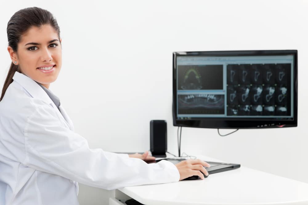 Dentist,With,Teeth,X ray,On,Screen