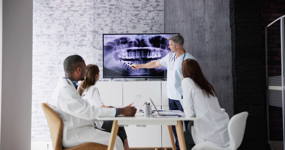 Team,Of,Dentists,Examining,Jaw,Xray,On,Computer,In,Hospital