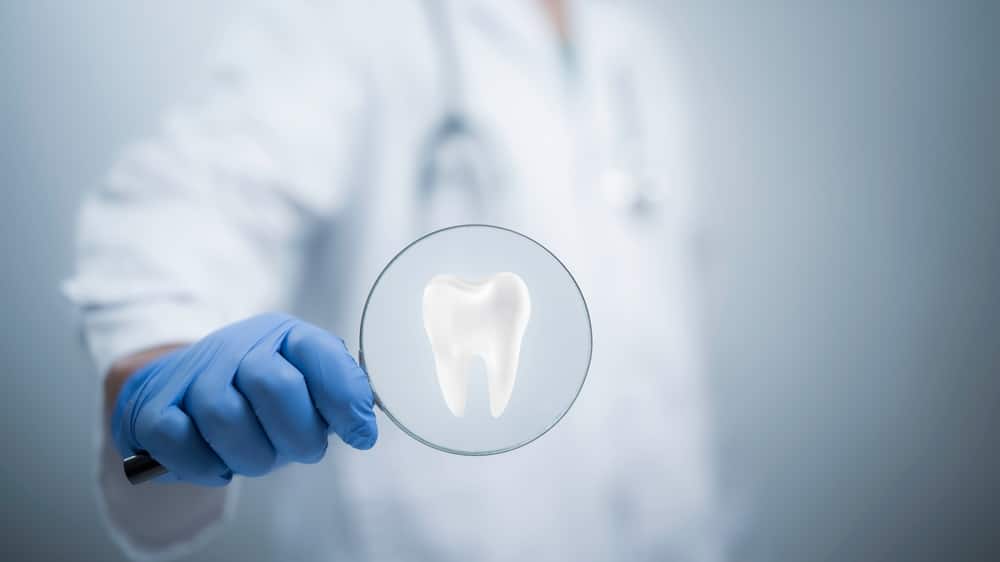 A,Professional,Dentist,Carefully,Holding,A,Magnifying,Glass,,Focusing,On